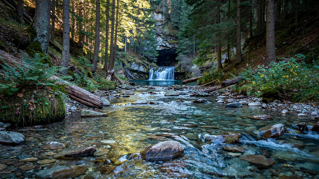 A clear mountain stream flowing over smooth stones through a temperate forest — finding, purifying, and storing clean water is the first foundation of self-reliance